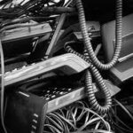Other services 14 A pile of discarded corporate office landline desk phones, tangled coiled receiver cords, and telecom e-waste cables ready for recycling.